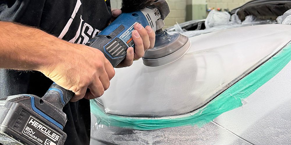 Profissional da Lasmar Car Detail polindo o farol de um carro com politriz, no processo de restauração